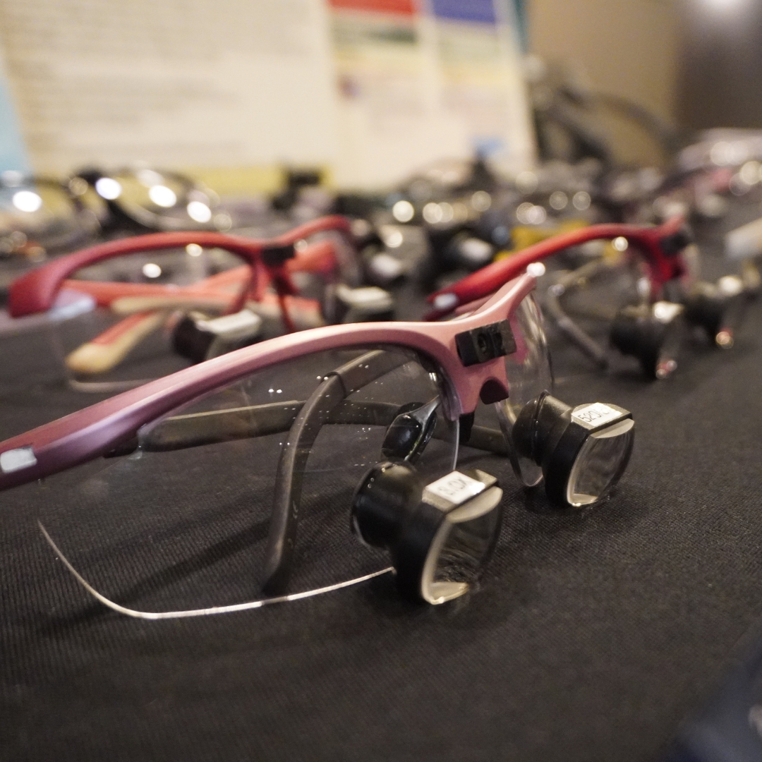A close up image of a table with colored dental loupes